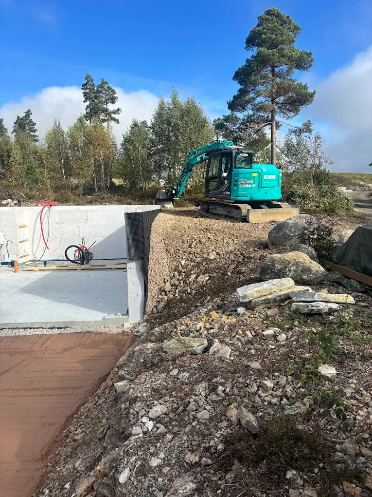 Gravemaskin i arbeid på byggeplass
